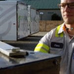 Commercial Tire employee standing in Cutting Edge Landscape yard with trailers in the background