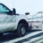 truck plowing snow on a road