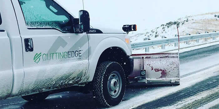 truck plowing snow on a road